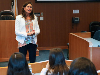 Person speaking to a class from the front of a lecture hall