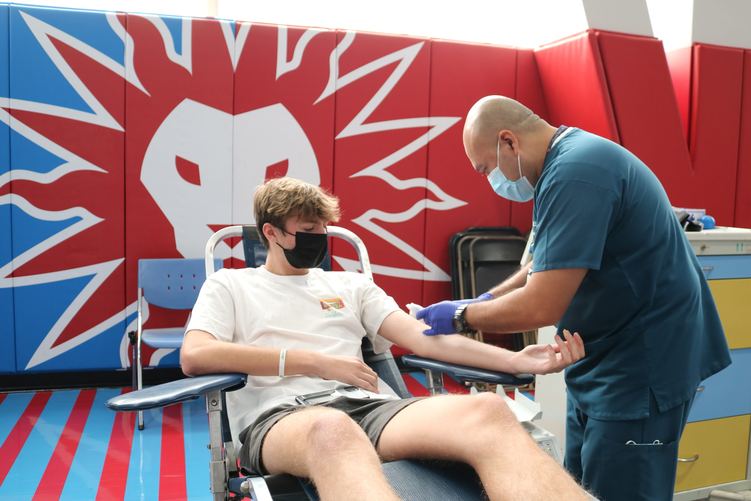 Male student donates blood in Burns Back Court during the fall blood drive.
