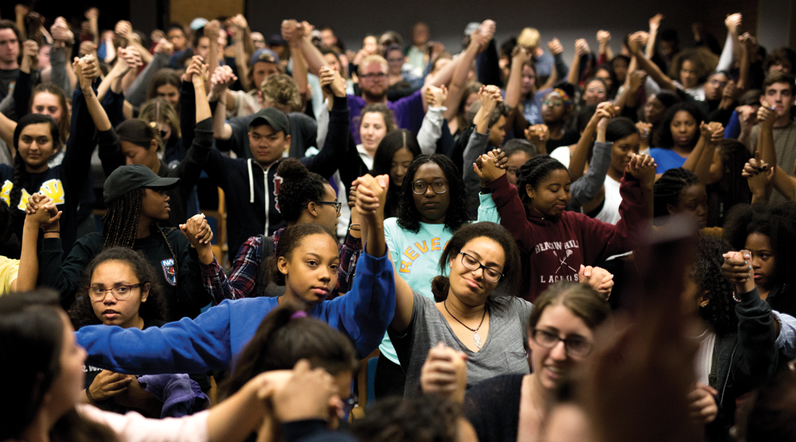 Image of students, faculty and staff holding hands