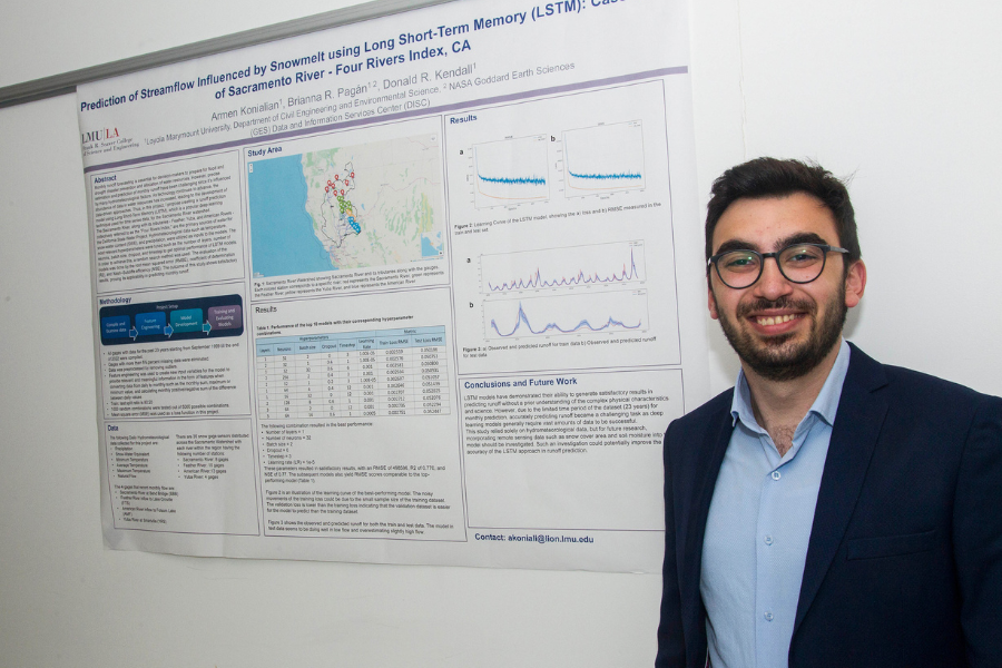 A student smile standing next to the poster board for their project titled Prediction of Streamflow Influenced by Snowmelt Using Long Short-Term Memory