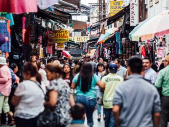 Crowd of people on a street with lots of small shops