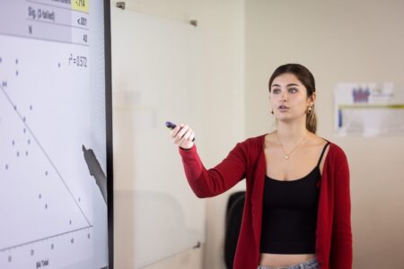 Female student in red sweater presenting research