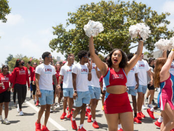 Cheerleaders and basketball players walk in the 4th of July parade.