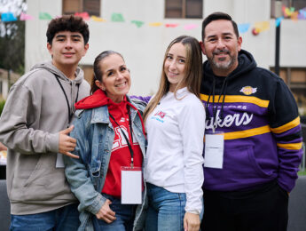 A family of four gathers outside on LMU's campus during LMU Family Weekend.