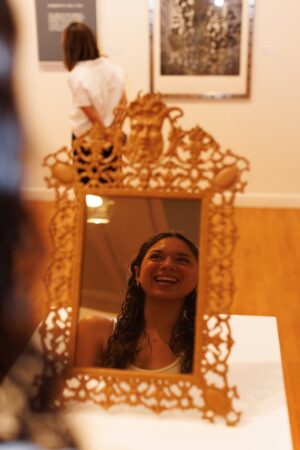 Student looks into a mirror on display in the exhibit