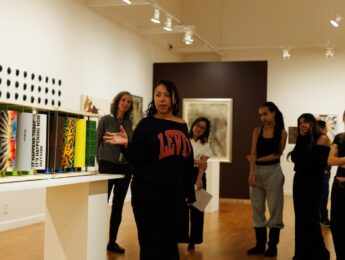 Student discussing piece of art on display at the Laband