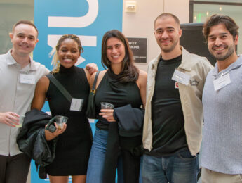 Five alums gather to pose inside University Hall for a photo during the 70 year anniversary celebration for the Office for International Students and Scholars.