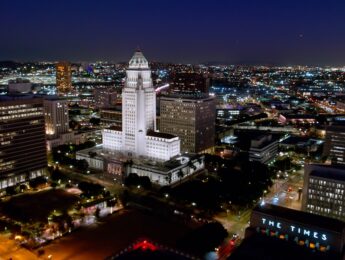 Aerial shot of City Hall and other government buildings in the Civic Center of Downtown Los Angeles (DTLA) at night.