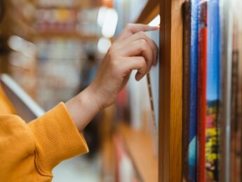 Person taking book off shelf