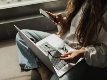 Student on a phone with laptop in her lap