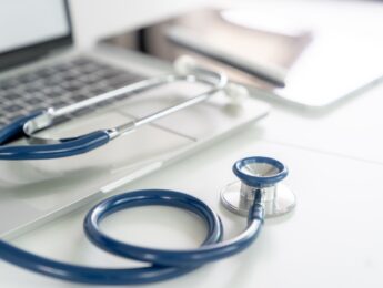 A stethoscope is placed on a doctor's desk in a hospital