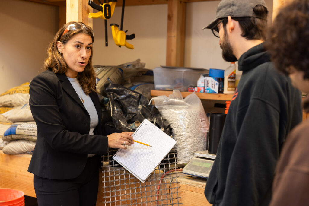Negin Tauberg helps student in concrete lab.