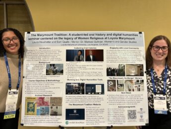 Two students stand smiling beside a research poster titled "The Marymount Tradition" dressed in business casual attire at conference.