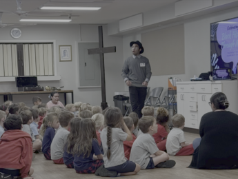 Student teaching in front of a classroom of young kids
