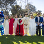Students and staff stand outside dressed in traditional attire to celebrate Lunar New Year.