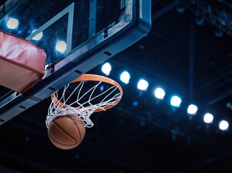 Basketball scoring a basket as it goes through the hoop and making a swish in the net.
