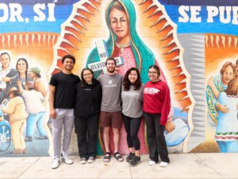 LMU student in front of colorful mural