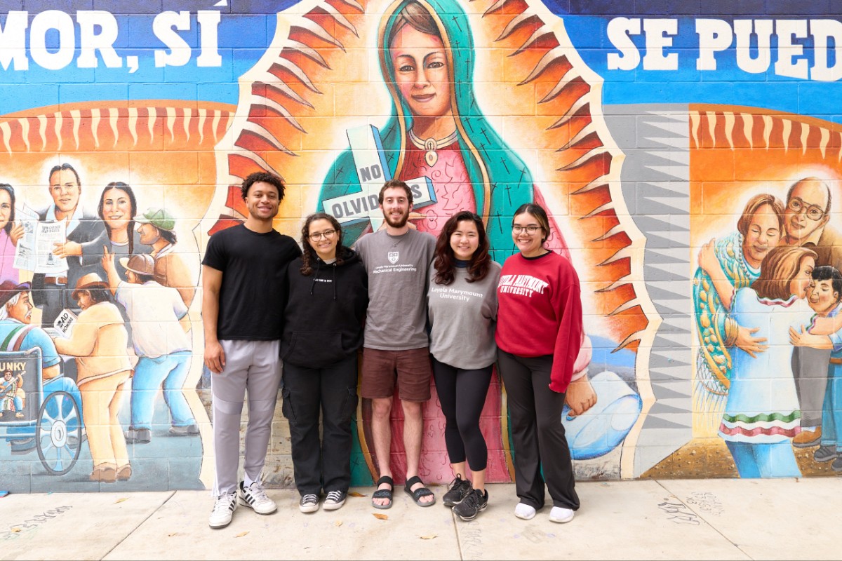 LMU student in front of colorful mural