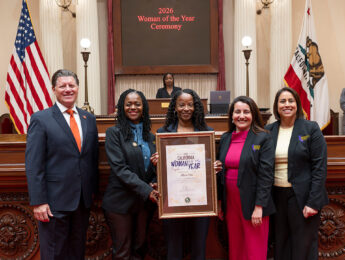 Members of the California Legislature pose with Kawanna Leggett holding a plaque for "2026 Woman of the Year."