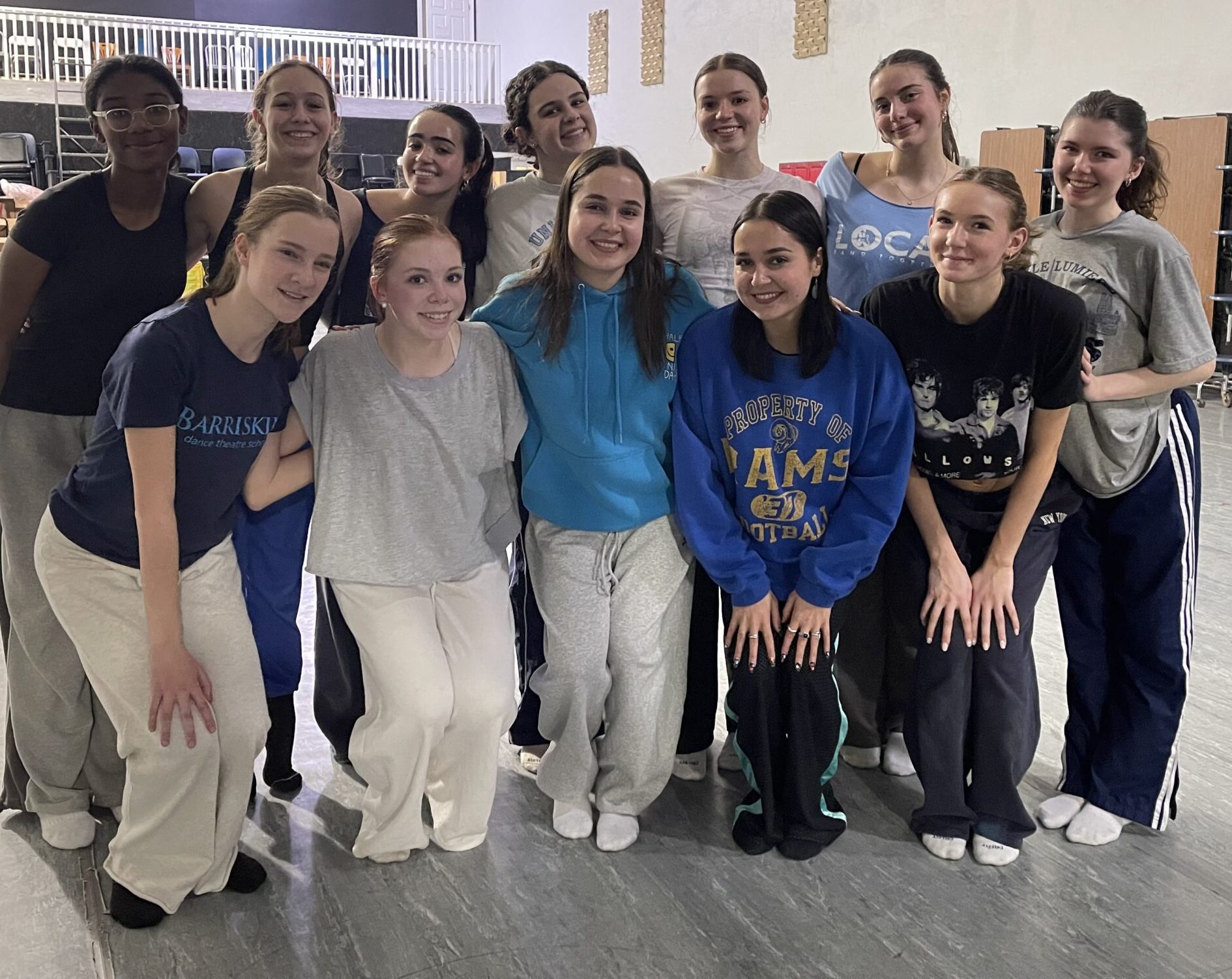 Twelve girls pose together in a dance studio