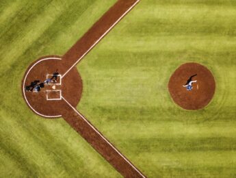 Extreme wide shot overhead view of pitcher throwing to batter during professional baseball game