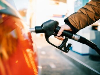 close-up of a hand in a gas pump fueling a car