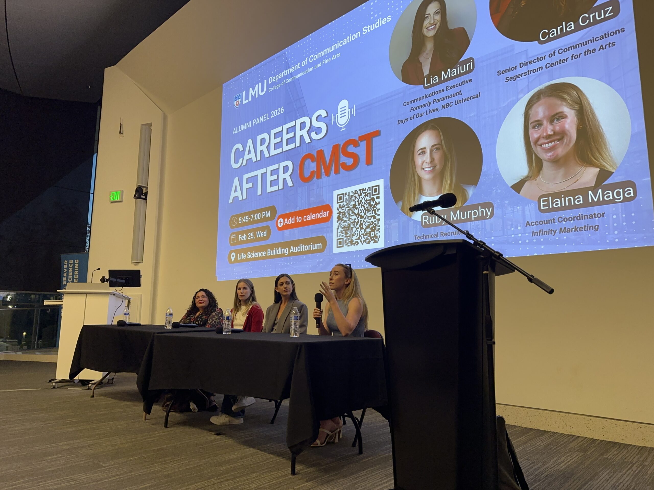 Four women sit behind a table near a microphone with a sign behind them that says "Careers After CMST"