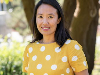Woman poses in yellow shirt with white polka dots