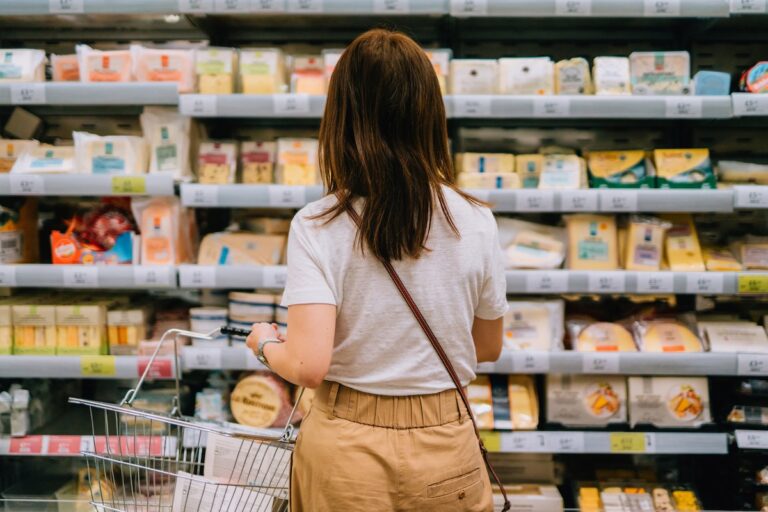 Woman choosing dairy products from the refrigerator in supermarket.