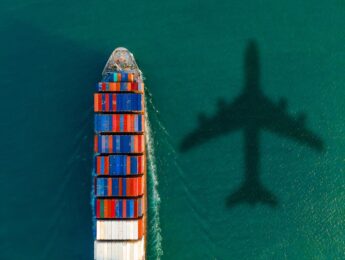 Barge in sea with shadow of plane