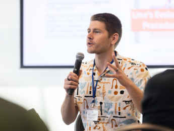 Jared Coleman, LMU computer science professor, holding microphone and speaking at AI and Indigenous Language Revitalization Workshop