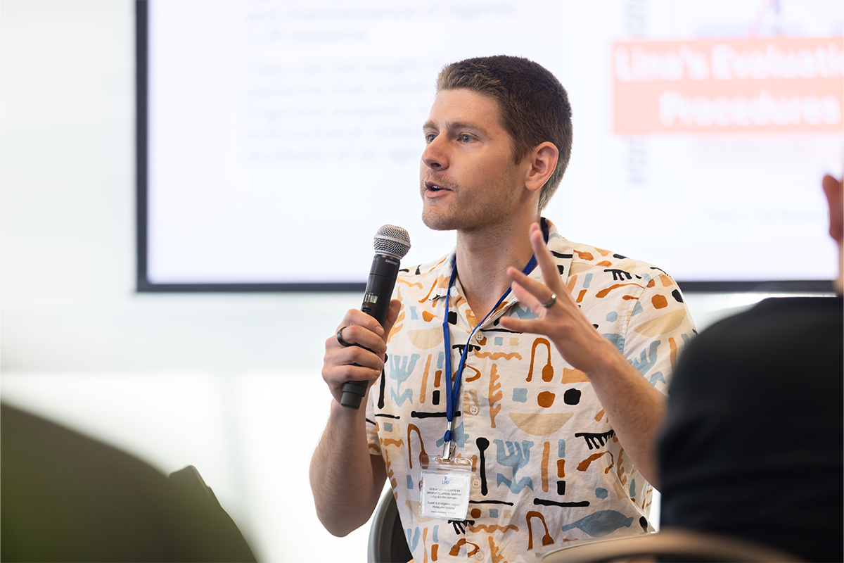 Jared Coleman, LMU computer science professor, holding microphone and speaking at AI and Indigenous Language Revitalization Workshop