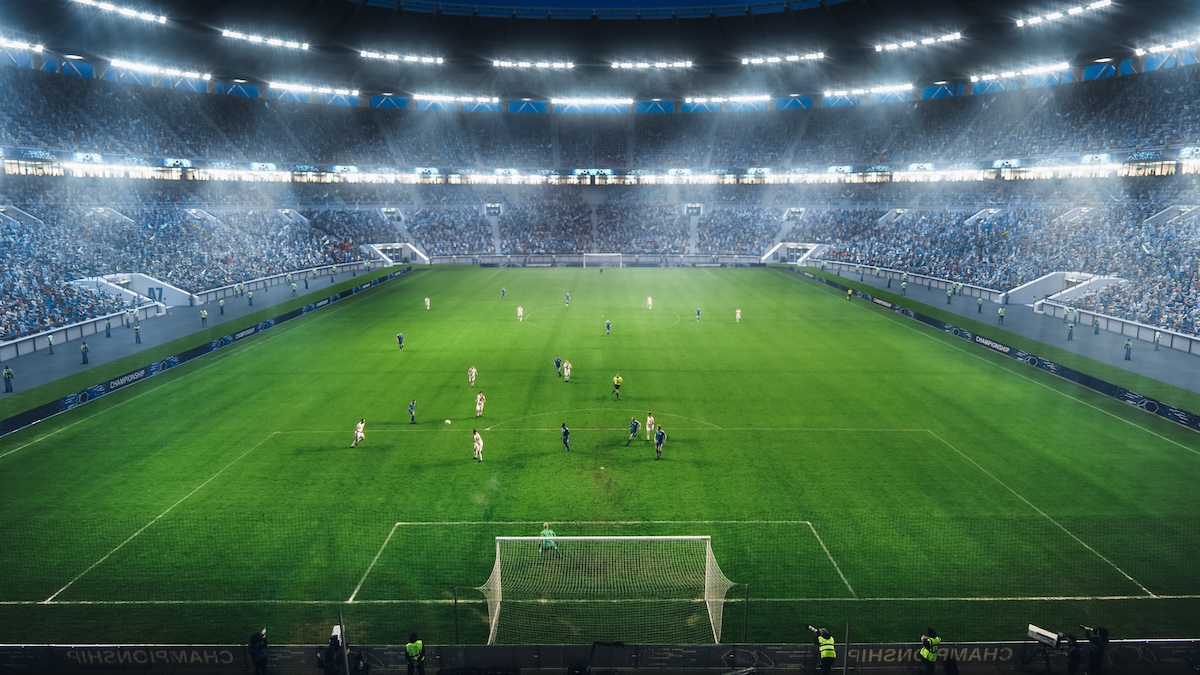 High Angle Shot Behind Goalkeeper Gates: Stadium with Soccer Championship Match. Teams Play, Crowds of Fans Cheer.