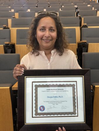 image of professor Deepa Dabir seated and holding award.
