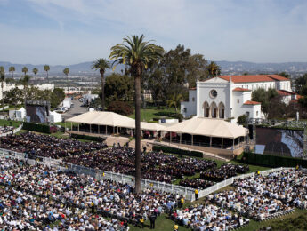 A wide aerial view of a university commencement ceremony held on a large lawn