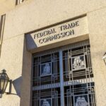 Exterior of the Federal Trade Commission (FTC) building in Washington, D.C., with a door under the sign depicting sailing ships.