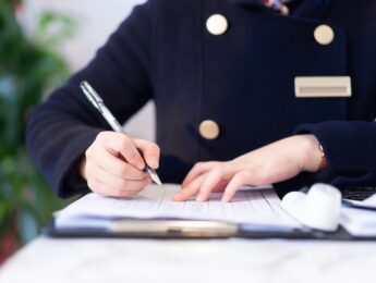 Hotel worker writing in notebook at counter