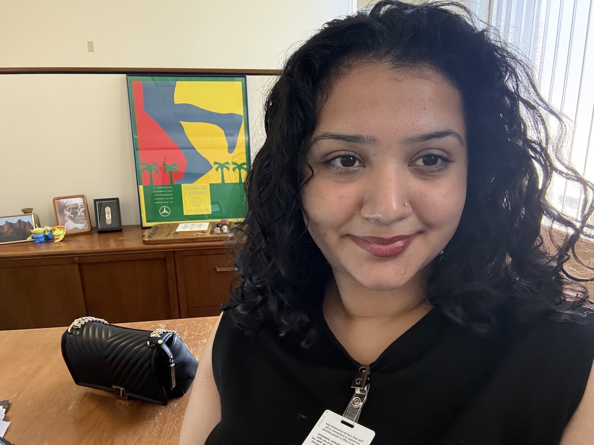 Rikisha Chahal smiling at desk in internship office