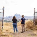 Demian Willette research with student in Ascot Hills Park overlooking DTLA