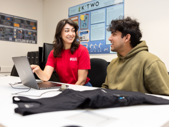 Delaram Yazdansepas, assistant professor of computer science, sitting next to computer science student Dayyan Chaudhri in the lab looking at a laptop
