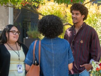 Miles Gibson outside talking to two women