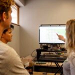 Study LA's Brianna Gilbert points to computer with students to explain GIS information