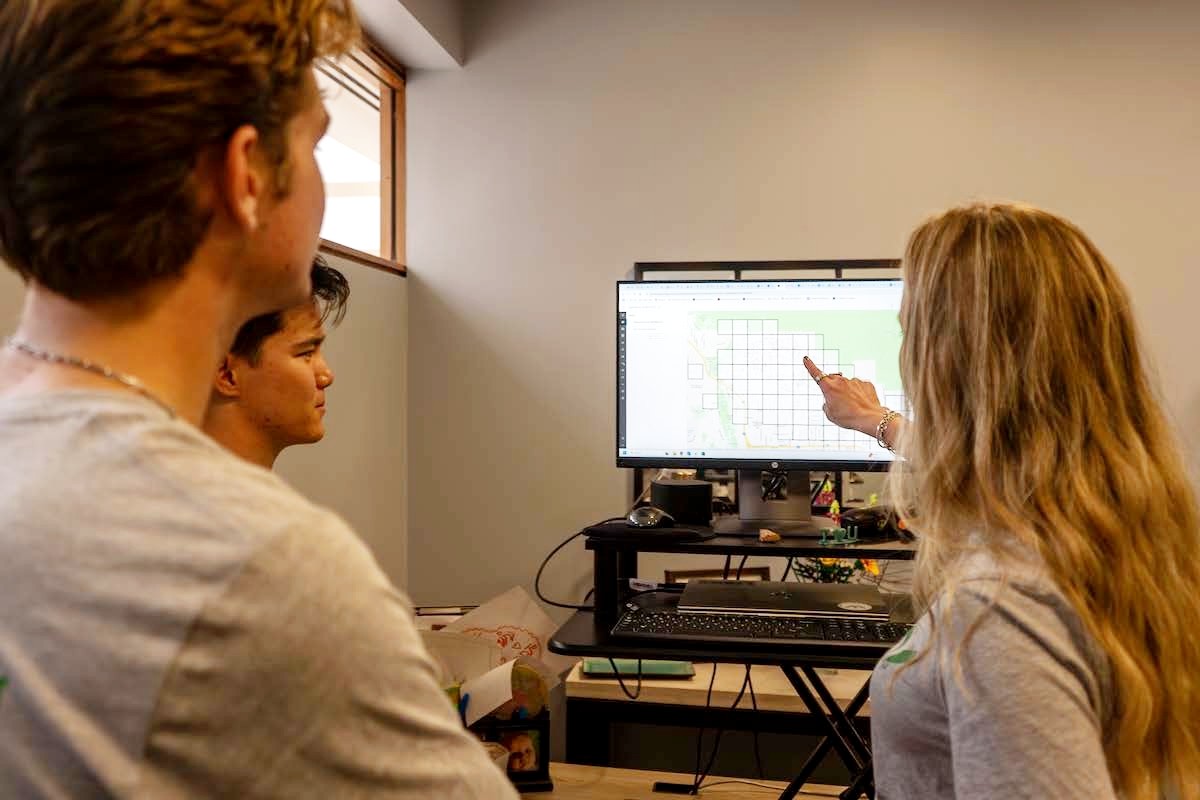 Study LA's Brianna Gilbert points to computer with students to explain GIS information