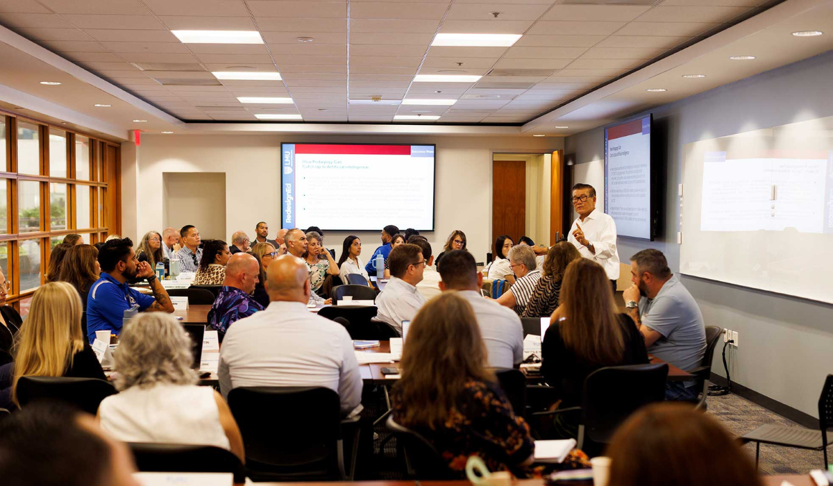 man giving a talk in front of seated adults in a classroom
