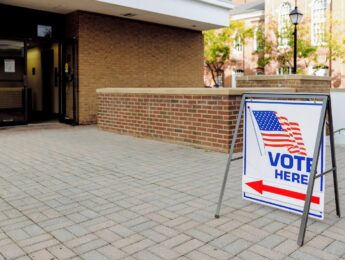 Close-up of "Vote Here" directional sign outside of polling place