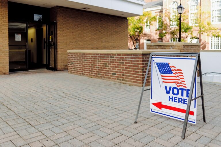 Close-up of "Vote Here" directional sign outside of polling place