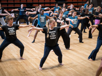 Group of women in T-shirts that say "Dance For Every Child" dancing in a studio