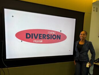 Trinity Collins standing in room in front of screen with text that reads youth diversion program.