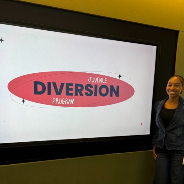Trinity Collins standing in room in front of screen with text that reads youth diversion program.