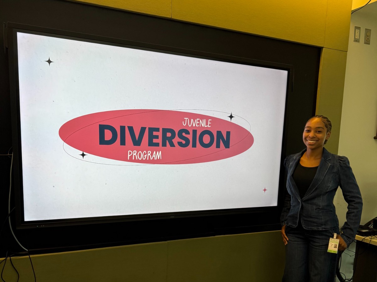 Trinity Collins standing in room in front of screen with text that reads youth diversion program.